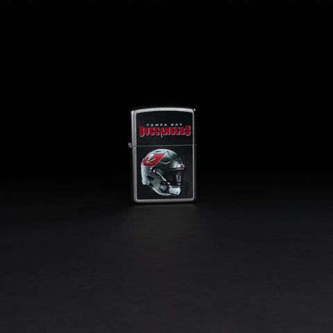 Lifestyle image of NFL Tampa Bay Buccaneers Helmet Street Chrome Windproof Lighter standing in a black background.