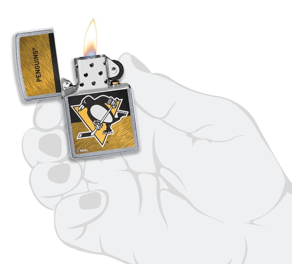 NHL® Pittsburgh Penguins Street Chrome™ Windproof Lighter lit in hand
