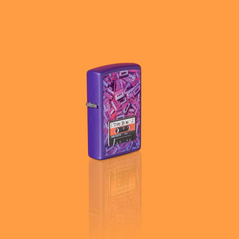 Glamour shot of Zippo Cassette Tape Design Purple Matte Windproof Lighter standing in an orange scene.