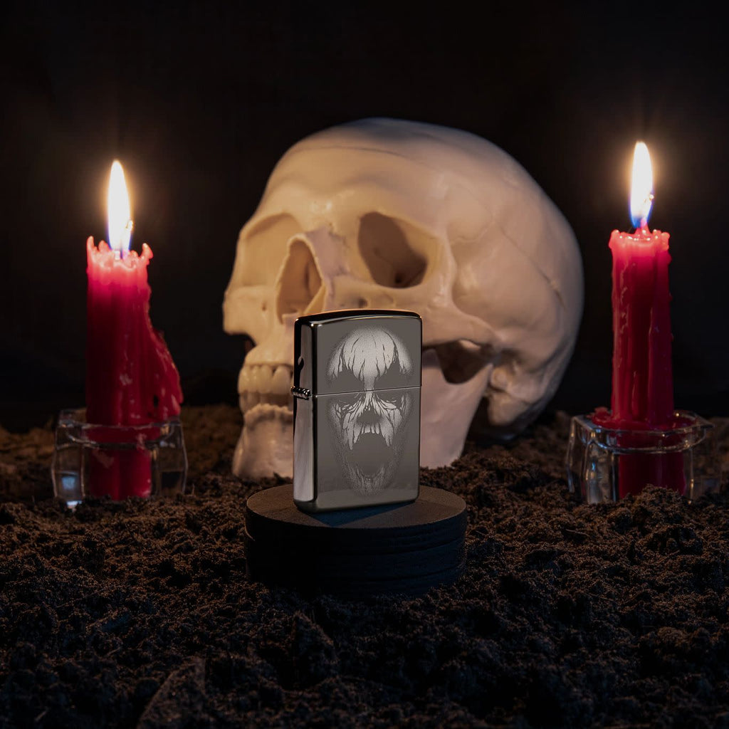 Lifestyle image of Screaming Monster Design Photo Image Black Ice® Windproof Lighter standing with a skull and lit candles behind it.