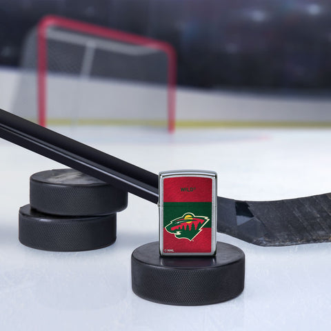 Lifestyle image of the NHL® Minnesota Wild™ Street Chrome™ Windproof Lighter standing with a hockey puck and hockey stick, with a hockey net in the background.