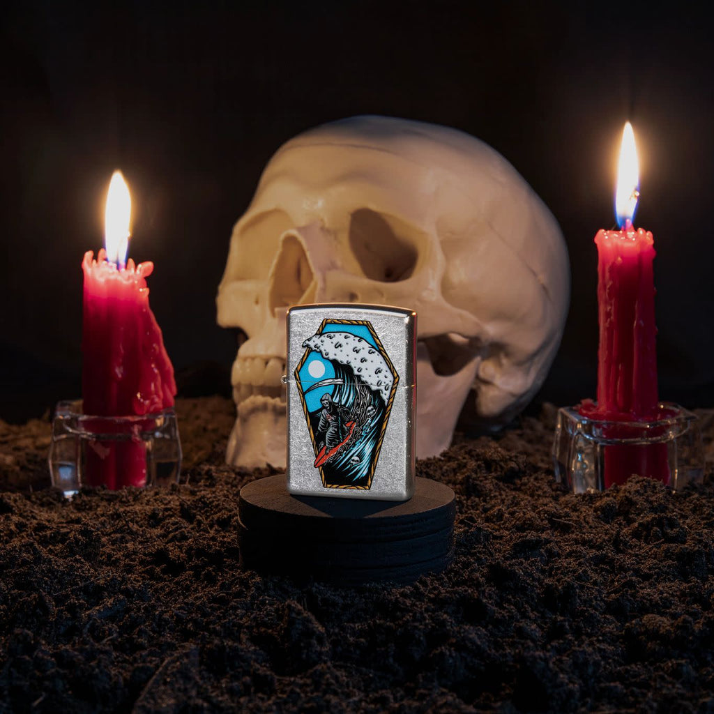 Lifestyle image of Reaper Surfer Design Street Chrome™ Windproof Lighter with a skull and lit candles in the background.