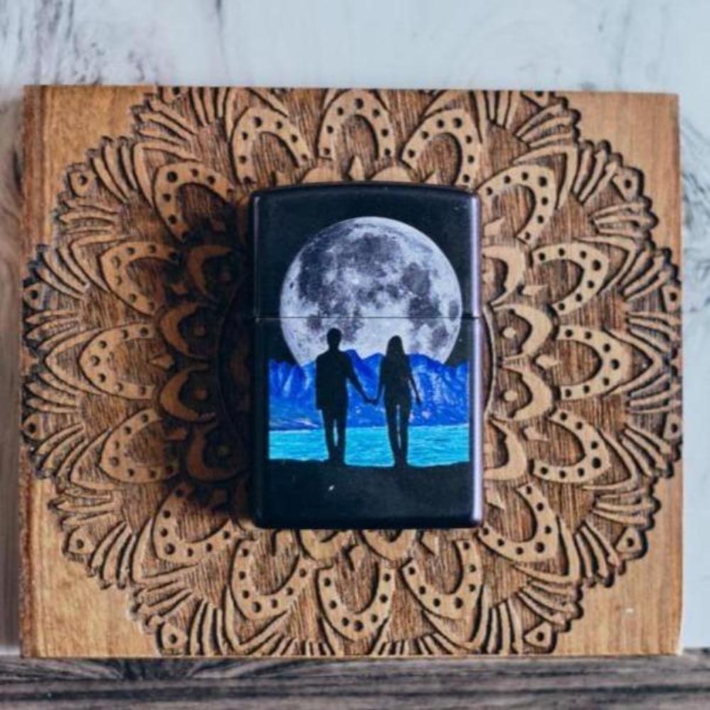 Front shot of Moon Couple Design Iridescent Windproof Lighter laying on a wooden mandala background
