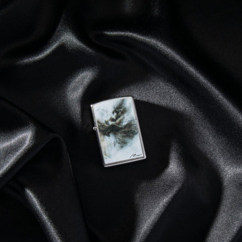 Lifestyle image of Luis Royo Design Street Chrome™ Windproof Lighter laying on a black cloth.