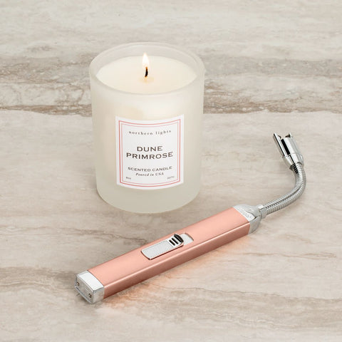 Lifestyle of Rose Gold Rechargeable Candle Lighter & 8 oz Dune Primrose Candle lit on a counter.