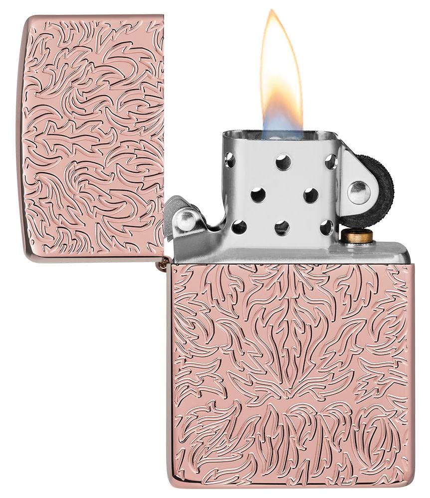 Zippo Carved Armor® Rose Gold Design Windproof Lighter with its lid open and lit.