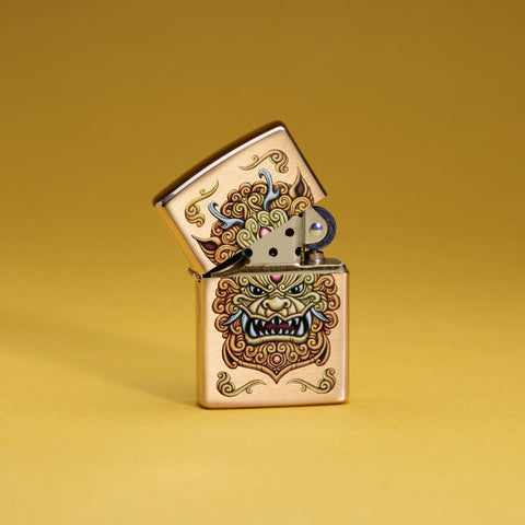 Lifestyle image of Zippo Foo Dog Design Brushed Brass Windproof Lighter standing in a golden scene.