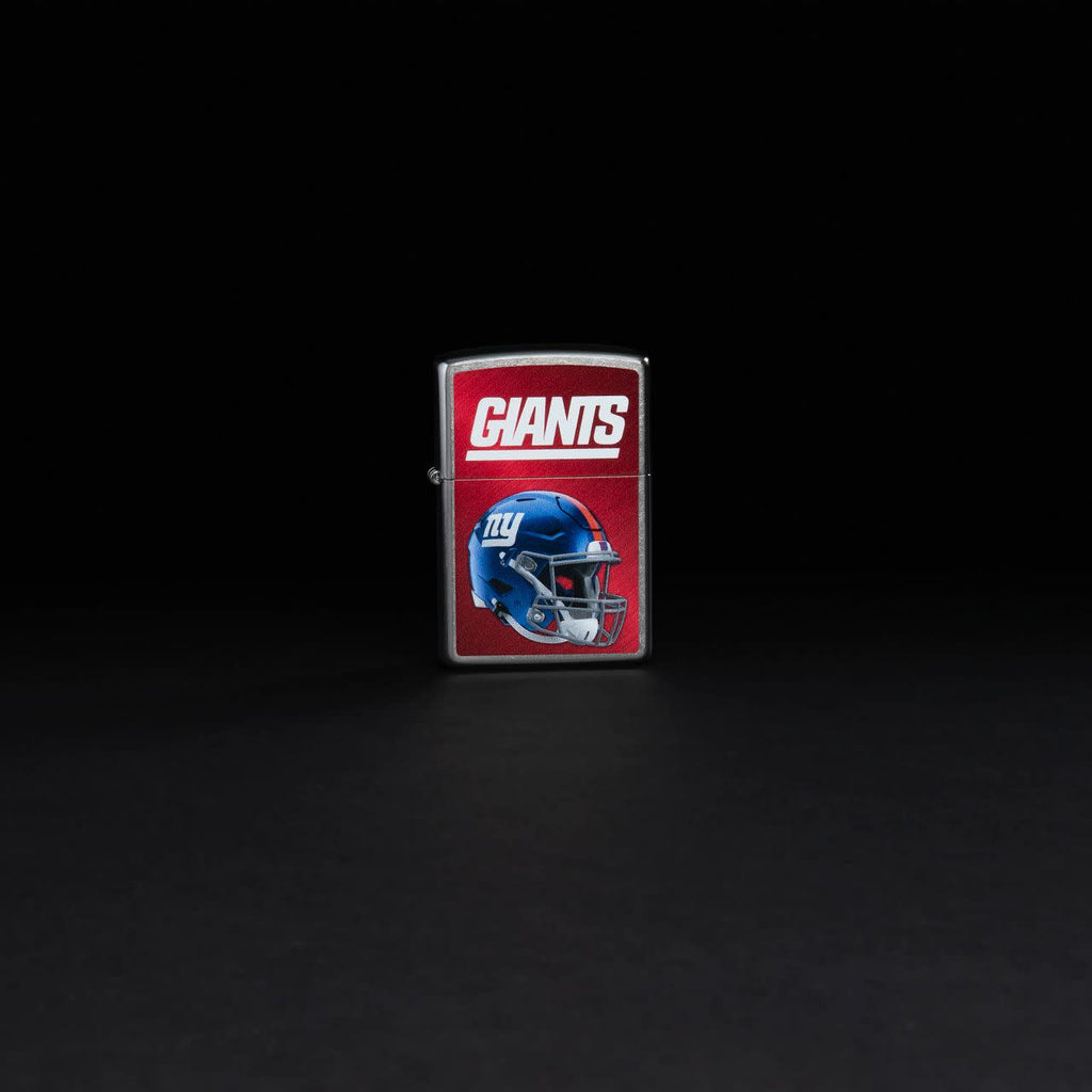 Lifestyle image of NFL New York Giants Helmet Street Chrome Windproof Lighter standing in a black background.