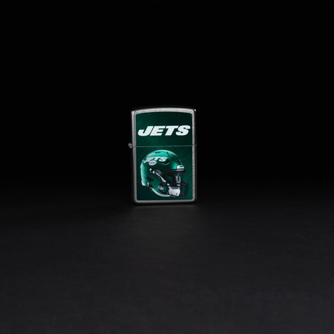 Lifestyle image of NFL New York Jets Helmet Street Chrome Windproof Lighter standing in a black background.