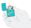 Chevy Script Logo Flat Turquoise Windproof Lighter lit in hand.