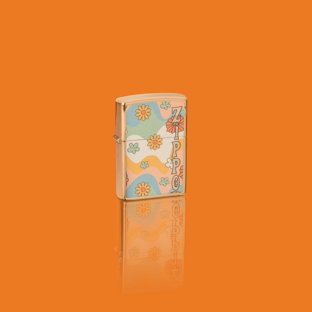 Glamour shot of Zippo Flower Power Design High Polish Brass Windproof Lighter standing in an orange scene.