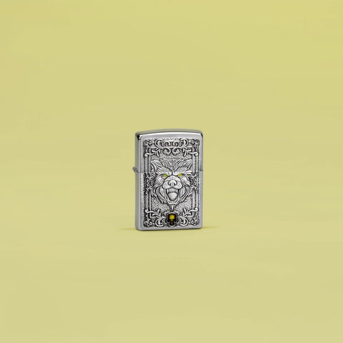 Lifestyle image of Zippo Wolf Emblem Design Brushed Chrome Windproof Lighter standing in a yellow scene.