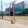 Lifestyle image of Vintage Design Slim Black Ice Windproof Lighter standing in front of the Zippo building.