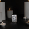 Lifestyle image of Medieval Skull Crest Linen Weave Windproof Lighter standing with lit candles.