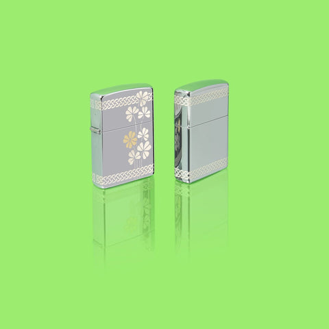 Lifestyle image of two Zippo Laser 360° Clover Design High Polish Chrome Pocket Lighters standing in a green scene.