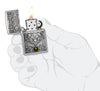 Zippo Wolf Emblem Design Brushed Chrome Windproof Lighter lit in hand.