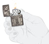 Day of the Dead Skull Cross Design Black Ice Windproof Lighter lit in hand.