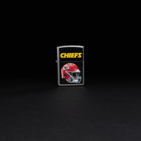 Lifestyle image of NFL Kansas City Chiefs Helmet Street Chrome Windproof Lighter standing in a black background.