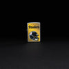 Lifestyle image of NFL Pittsburgh Steelers Helmet Street Chrome Windproof Lighter standing in a black background.
