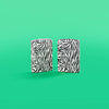 Lifestyle image of Zebra Print Design 540 Color Windproof Lighters standing in a green background.