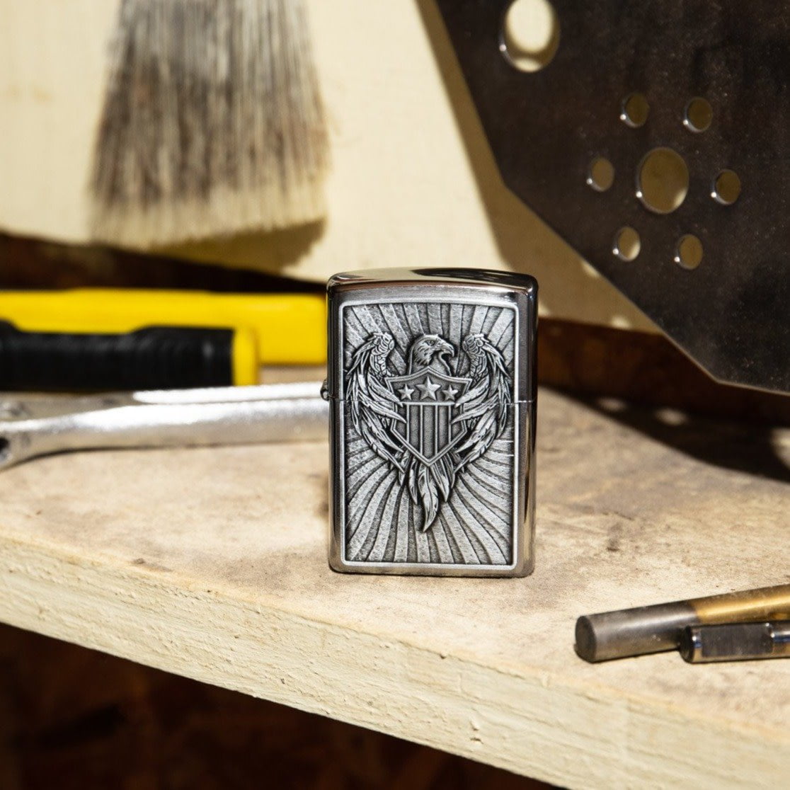 Lifestyle image of Eagle Shield Emblem Design Street Chromeâ„¢ Windproof Lighter standing on a workbench with tools.