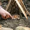 Lifestyle image of Fire Starting  Paracord on fire and about to lite tinder in a campfire.