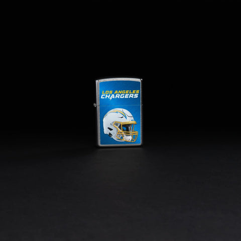 Lifestyle image of NFL Los Angeles Chargers Helmet Street Chrome Windproof Lighter standing in a black background.
