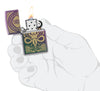 Zippo Evil Design Iridescent Windproof Lighter lit in hand.