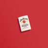 Lifestyle image of Jim Beam Label Logo White Matte Windproof Lighter laying on a red background.