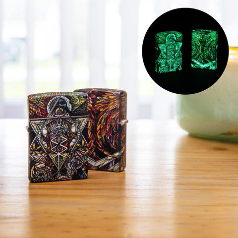 Lifestyle image of two Abstract Psychedelia 540 Color Glow-In-The-Dark Windproof Lighter, standing on an end table with a Northern Lights candle. One lighter is showing the front of the design, and the other is shjowing the back. In the corner is a circular picture of the ligthers glowing in the dark.