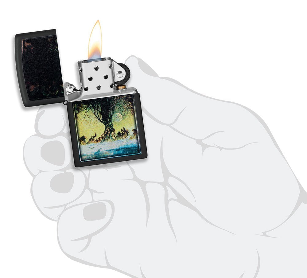 Frank Frazetta Tree Design Black Matte Windproof Lighter lit in hand.