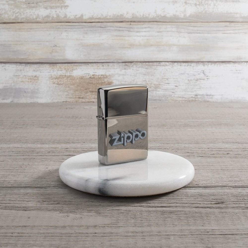 Lifestyle image of Zippo 3D Logo Design Black IceÂ® Windproof Lighter standing on a marble coaster.