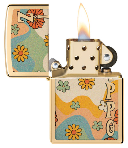 Zippo Flower Power Design High Polish Brass Windproof Lighter with its lid open and lit.
