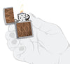 WOODCHUCK USA Walnut Leaves Two-Sided Emblem Windproof Lighter lit in hand.