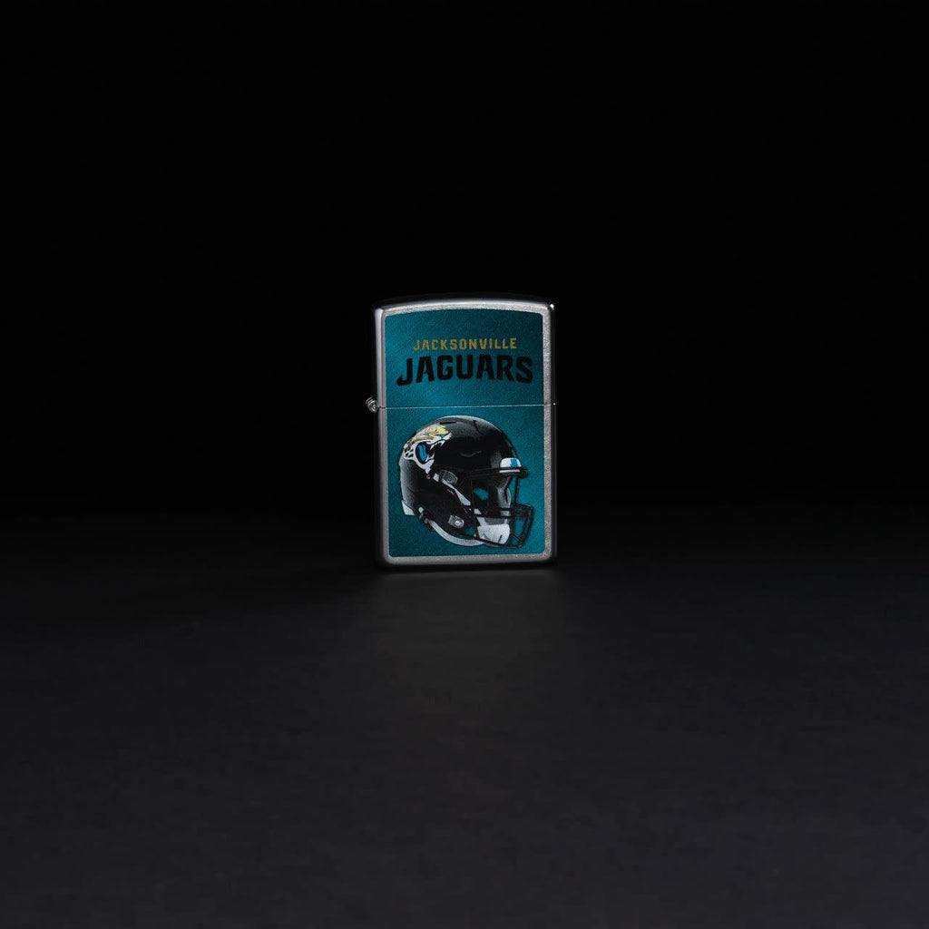 Lifestyle image of NFL Jacksonville Jaguars Helmet Street Chrome Windproof Lighter standing in a black background.